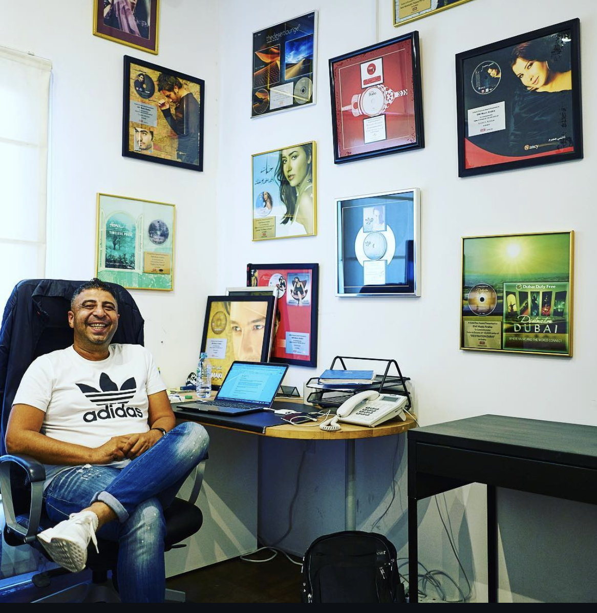 Richard Hussein at his Lionheart office with 20+ years of Gold and Platinum awards